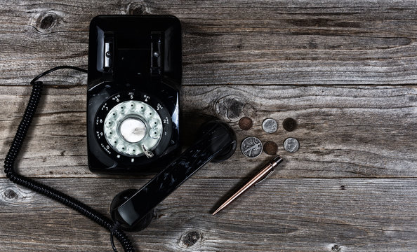 Old telephone with various old vintage objects on stressed wood