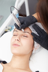 Naklejka premium beautiful young lady getting tattoo. professional tattooist making eyebrow make up