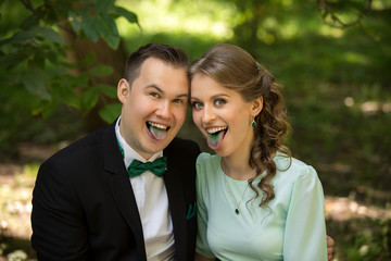 Man and woman grimacing with green tongues. Green wedding or saint patrick day concept