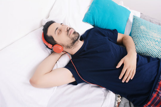 Man listening to music in bed.