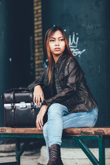 Obraz na płótnie Canvas Gorgeous girl in leather jacket posing on the bench