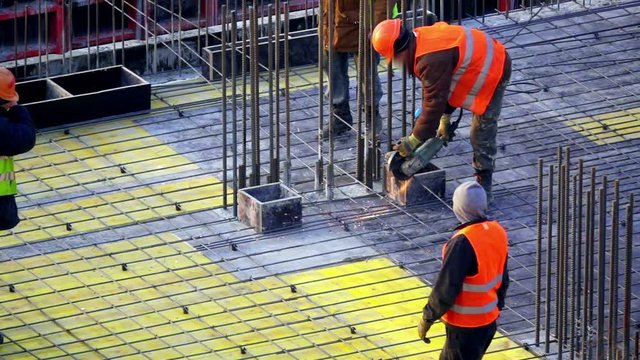  Slow motion construction worker cuts rebar with an angle grinder