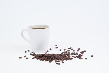 Cup of black coffee in a white mug with coffee beans