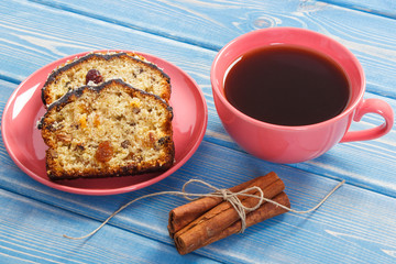 Cup of coffee and fresh baked fruitcake on boards