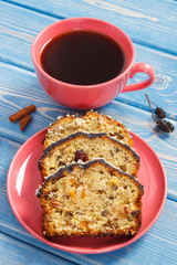 Cup of coffee and fresh baked fruitcake on boards
