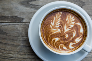 Close up top view latte coffee on natural wood table.