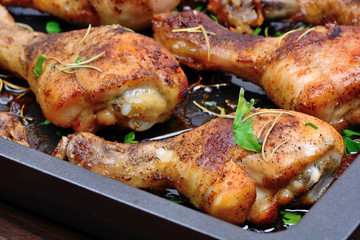 Many chicken legs in pan on table