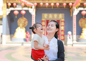 portrait of mother and cute little girl in Yaowarat Road (Bangkok chinatown) at Chinese new year, Bangkok Thailand.