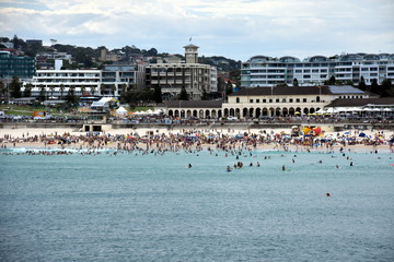 Sydney, Australia - Feb 5, 2017. People relaxing, swimming and sun bathing on Bondi beach. Bondi Pavilion in the background. Bondi beach is one of the most famous tourist sites in Australia.