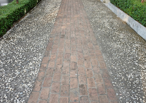 An old garden walkway constructed of bricks and mortar.