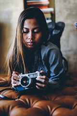 Beautiful young girl holding camera, hipster style