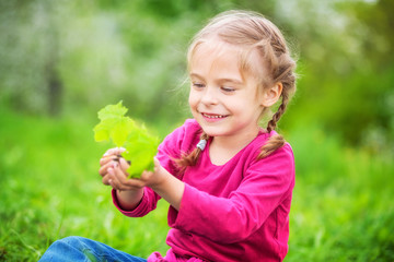 Little girl holding little green plant in hands. Ecology concept