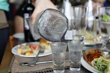 Waiter pouring vodka from carafe