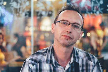 Handsome man in a cafe outside drinking coffee