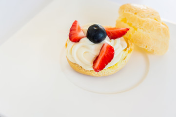 Homemade, Homemade cake, Choux Cream with fresh blueberry and strawberry decorated on white background at house.