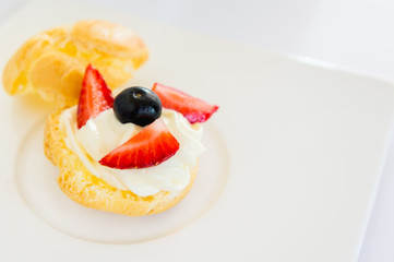 Homemade, Homemade cake, Choux Cream with fresh blueberry and strawberry decorated on white background at house.