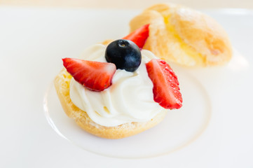 Homemade, Homemade cake, Choux Cream with fresh blueberry and strawberry decorated on white background at house.