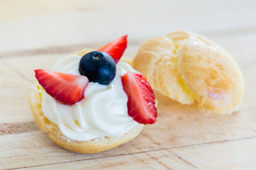 Homemade, Homemade cake, Choux Cream with fresh blueberry and strawberry decorated on wooden background at house.