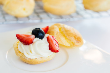 Homemade, Homemade cake, Choux Cream with fresh blueberry and strawberry decorated on white background at house.