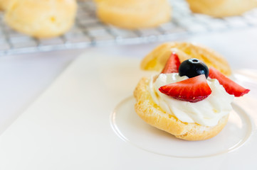 Homemade, Homemade cake, Choux Cream with fresh blueberry and strawberry decorated on white background at house.