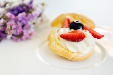 Homemade, Homemade cake, Choux Cream with fresh blueberry and strawberry decorated on white background at house.