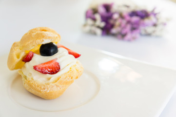 Homemade, Homemade cake, Choux Cream with fresh blueberry and strawberry decorated on white background at house.