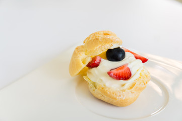 Homemade, Homemade cake, Choux Cream with fresh blueberry and strawberry decorated on white background at house.