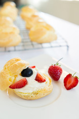 Homemade, Homemade cake, Choux Cream with fresh blueberry and strawberry decorated on white background at house.