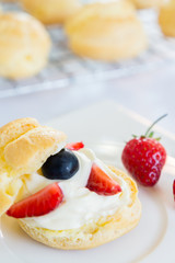 Homemade, Homemade cake, Choux Cream with fresh blueberry and strawberry decorated on white background at house.