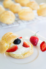 Homemade, Homemade cake, Choux Cream with fresh blueberry and strawberry decorated on white background at house.