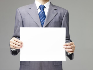 businessman holding a piece of blank paper