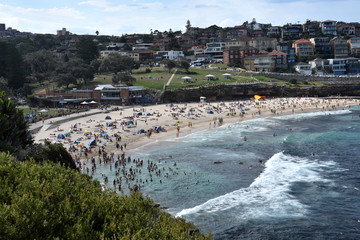 People relaxing, swimming and sun bathing on Bronte beach.