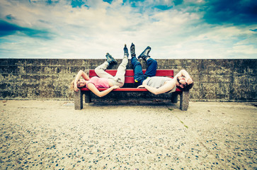Fototapeta na wymiar Young tired people friends relaxing on bench.