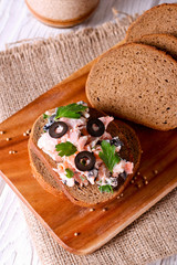 Smoked salmon and soft cheese spread, mousse, pate on a bread with olives and parsley