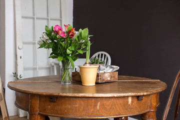 Vase and pot of flowers on table