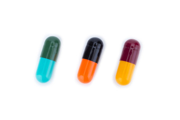 Three capsule color Red Yellow Blue Green Orange and Balck isolated on white background