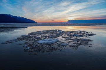Drifting ice formations on water surface on sunrise © Aniland