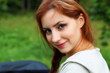 Fototapeta premium red-haired girl in a park sunny day outdoor