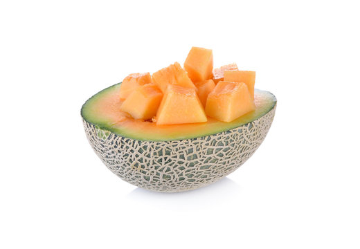 half and cube cut ripe cantaloupe on a white background
