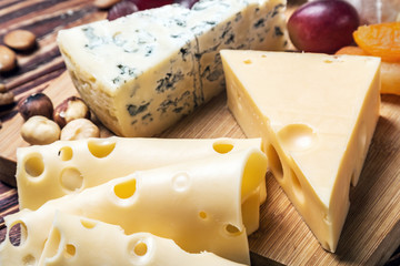 Assorted cheese with nuts and grapes on the table