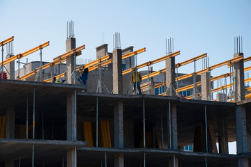 Fototapeta premium Construction workers installing mounting horizontal formwork on the building construction site.