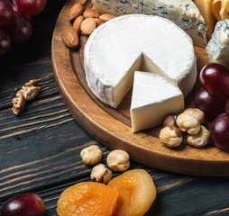 Assorted cheeses with nuts and dried fruits on the table