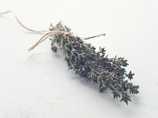Bunch of fresh garden thyme arranged on white wooden table. Selective focus. Copy space for your text.