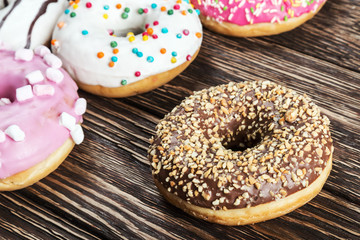 Assorted chocolate glazed donuts on a wooden table