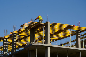 Construction workers installing mounting horizontal formwork on the building construction site.