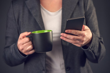 Businesswoman reading sms message on coffee break