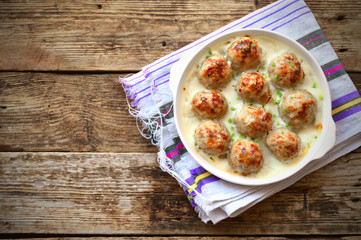 Meatballs in a white sauce. Food Photography. Wooden background.