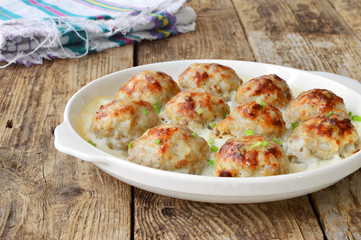 Meatballs in a white sauce. Food Photography. Wooden background.