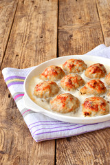 Meatballs in a white sauce. Food Photography. Wooden background.