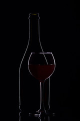 Wine glasses with wine bottle on a black background, minimalism, silhouette